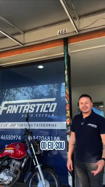 Integrante da equipe ao lado da moto de aula na fachada da Fantástico