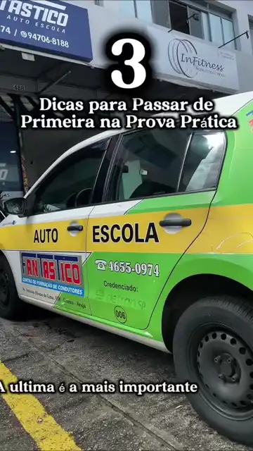 Carro da autoescola verde e amarelo em frente à fachada